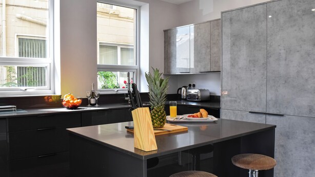 A modern kitchen with a central island, bar stools, a window with a view, and a built-in toaster. - A spacious property perfect for families and friends. (Bispham, near Blackpool)