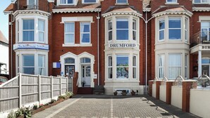 A Victorian-style building with a bay window, a prominent 'DRUMFORD' sign, and a gated entrance. - A spacious property perfect for families and friends. (Bispham, near Blackpool)