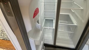Ein Kühlschrank mit einem Gefrierfach, einer Bedienblende und einer Glastür.