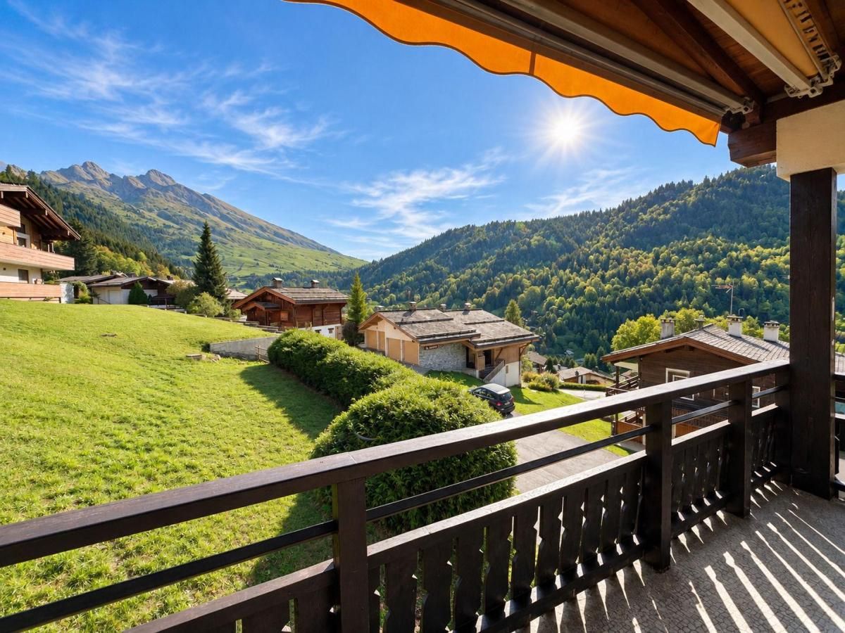 Een balkon met uitzicht op een groen landschap en bergen.