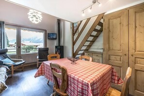 A cozy dining area with a checkered tablecloth, wooden chairs, a sofa, and a view of the outdoors. - 1st floor, view mountain, balcony, fireplace or stove, tv, ski locker, 55m², La Clusaz (La Clusaz)
