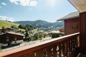 A balcony with a view of a village, mountains, and a clear sky. - 250m from ski slopes, 2nd floor, view resort/mountain, balcony, tv, ski locker, 26m², La Clusaz (La Clusaz)