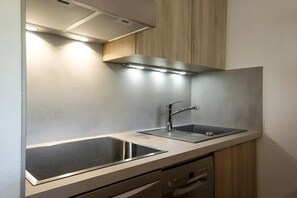 A modern kitchen with a stainless steel sink, a built-in oven, and a dishwasher.