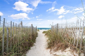 A sandy path leading to a beach with a wooden fence on either side. - 2BR Condo Sleeps 6 • Pool & Steps to Beach (Panama City Beach)