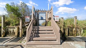 A set of concrete stairs leading to a gated entrance with warning signs. - 2BR Condo Sleeps 6 • Pool & Steps to Beach (Panama City Beach)