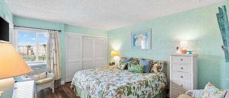 Quarto com cama, penteadeira, cadeira e abajur.