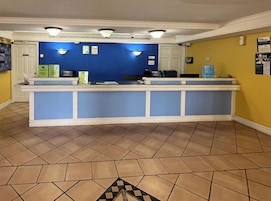 A reception area with a blue counter, tiled floor, and yellow walls.