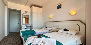 A hotel room with two beds, a wardrobe, a mirror, and wall-mounted lights. - Hotel Albora (Kusadasi)