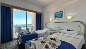 A hotel room with two beds, a balcony with a view of the sea, and a framed picture on the wall. - Hotel Albora (Kusadasi)