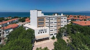 A multi-story hotel with a sign reading "Alborá Otel" and a view of the sea. - Hotel Albora (Kusadasi)
