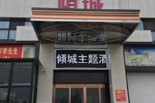 A building facade with a prominent sign in Chinese characters, a large entrance door, and a smaller sign above the door.