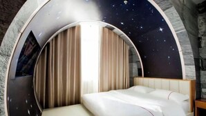 A circular room with a bed, curtains, and a starry wall. - Yueyang Qingcheng Theme Hotel (Yueyang County)