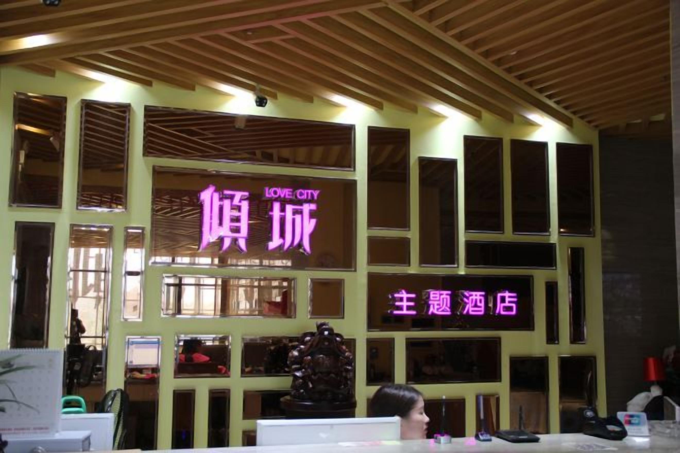 A hotel with a prominent neon sign, multiple windows, and a wooden ceiling.