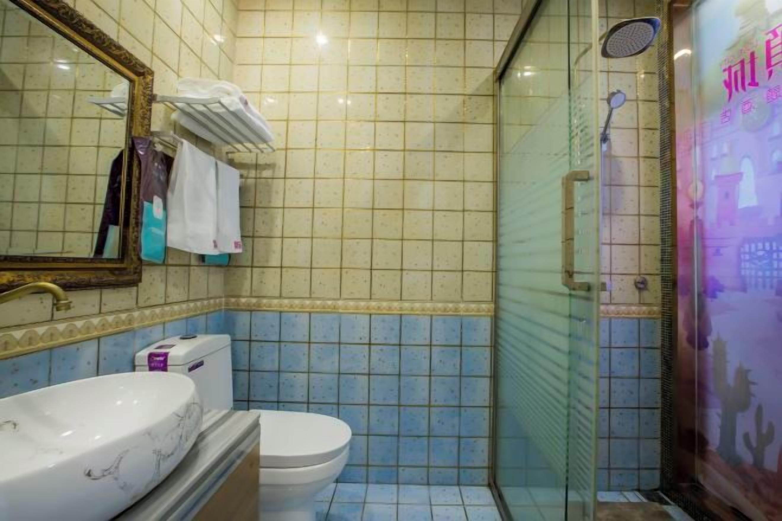 A bathroom with a marble sink, a toilet, and a glass-enclosed shower.