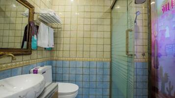 A bathroom with a marble sink, a toilet, and a glass-enclosed shower.