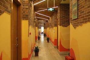 A corridor with brick walls, wooden doors, and potted plants. - Yueyang Qingcheng Theme Hotel (Yueyang County)