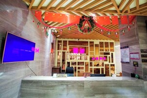 Un área de recepción con techo de madera, un televisor de pantalla plana y un mostrador de recepción.