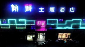 A hotel entrance with illuminated signage in multiple languages, including English and Chinese. - Yueyang Qingcheng Theme Hotel (Yueyang County)