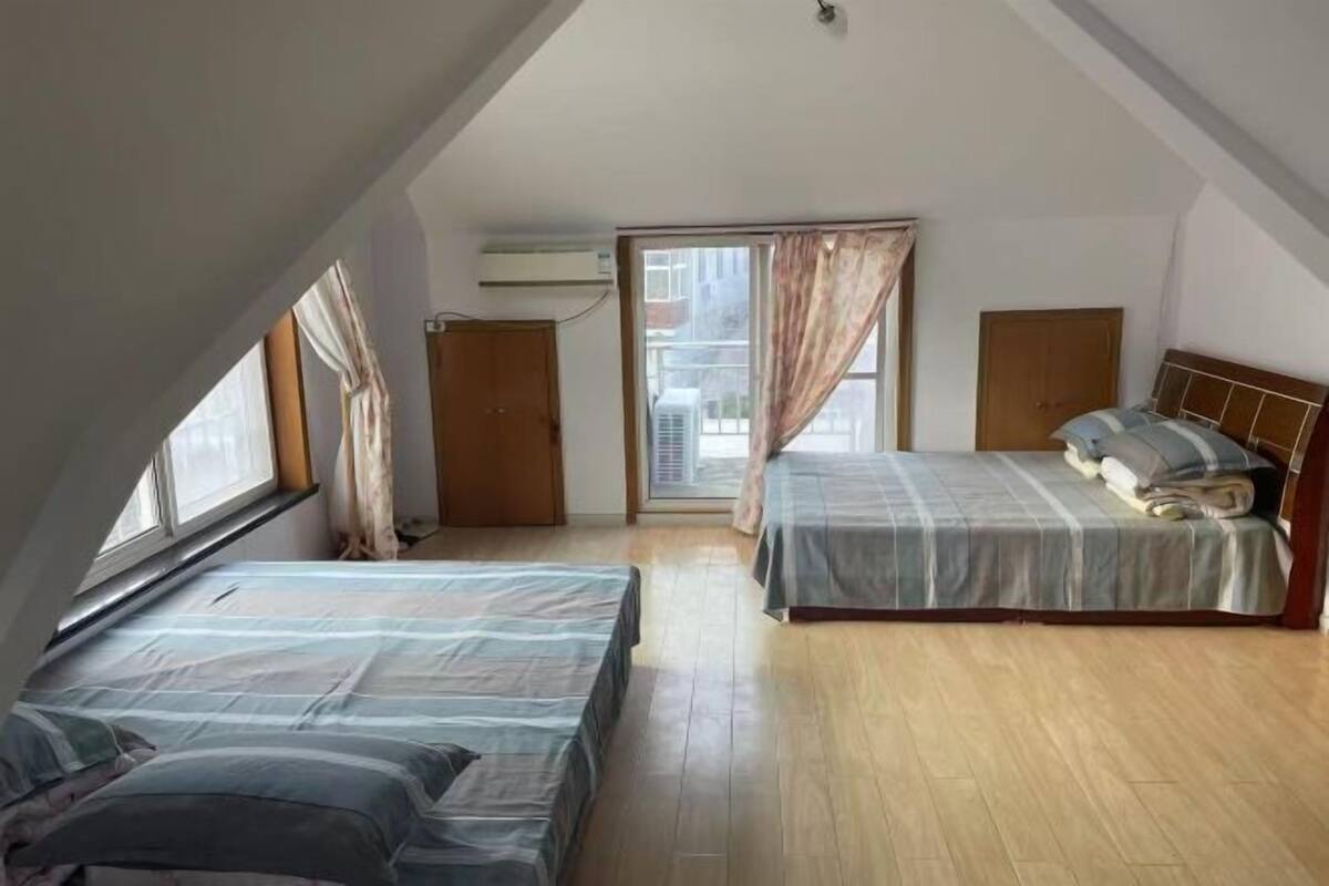Ein Schlafzimmer mit zwei Betten, einem Fenster und einer Klimaanlage.