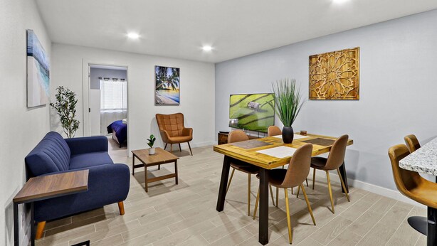 A modern living room with a sofa, dining table, chairs, and artwork on the walls. - NEW! Modern 3-Bedroom Retreat Fully Updated! (El Paso)