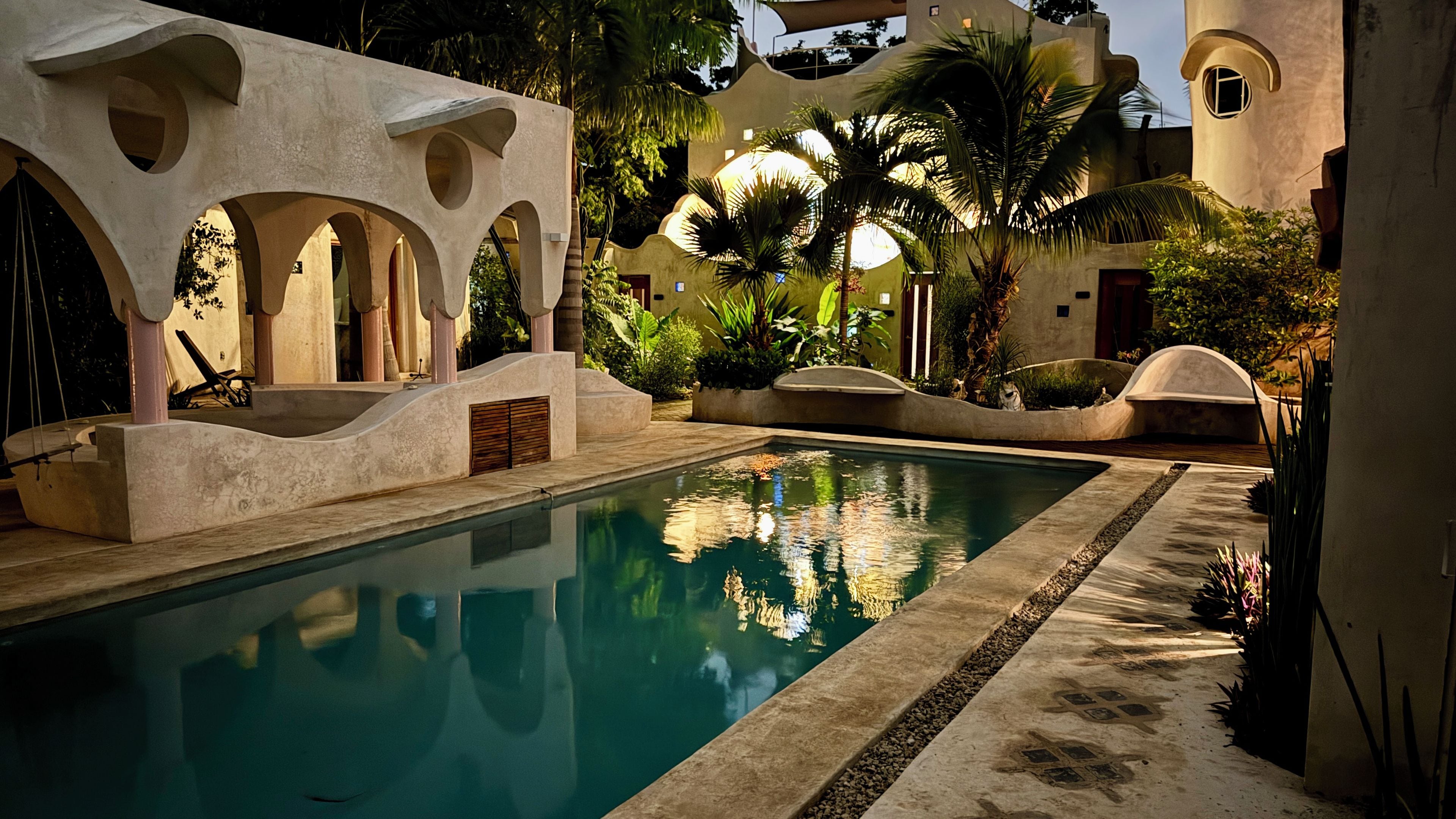Una piscina al aire libre, sombrillas, tumbonas