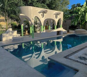 Alberca al aire libre, sombrillas en la alberca y camastros 