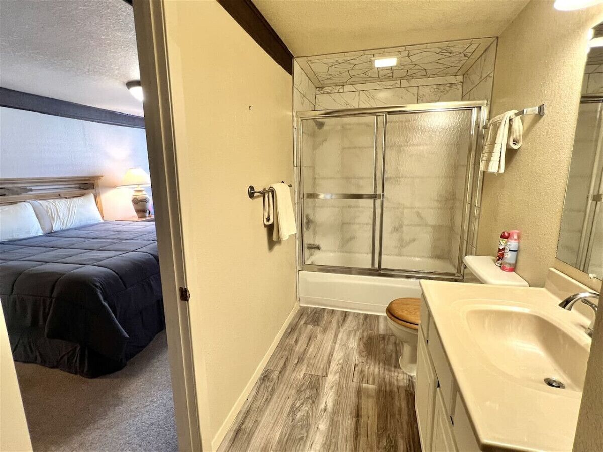 A compact bathroom with a shower, toilet, and sink.