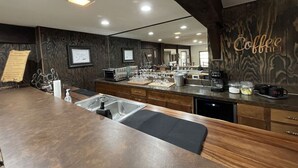 A modern kitchen with a wooden countertop, built-in appliances, and a coffee station.