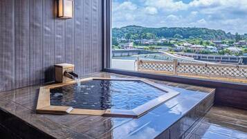 A spa area with a hot tub and a view of a bridge and houses.