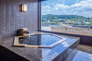 Zona de spa con jacuzzi y vistas a un puente y casas.