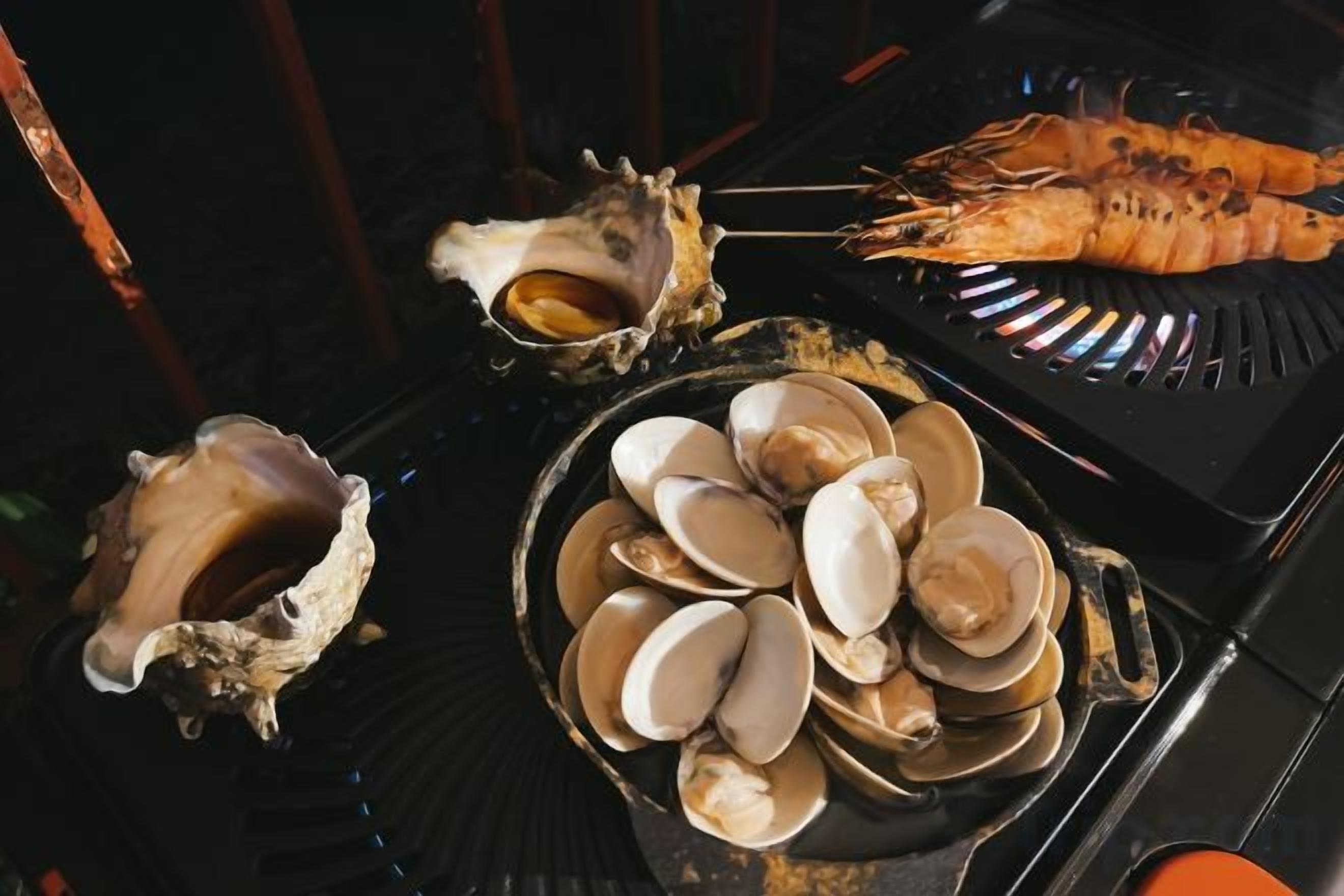 A seafood grill with oysters and shrimp.