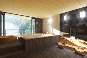 A modern bathroom with a large bathtub, a separate soaking tub, and a view of a lake.