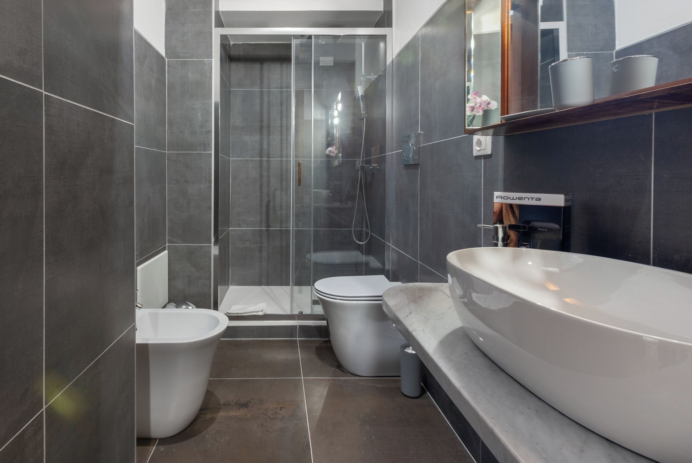Une salle de bain moderne équipée d’une baignoire, de toilettes et d’un espace douche.