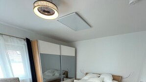 A modern hotel room with a bed, a chair, a desk, and a wardrobe. - Comfortable 2-bedroom apartment with WiFi in Lovely Plieningen! (Stuttgart)