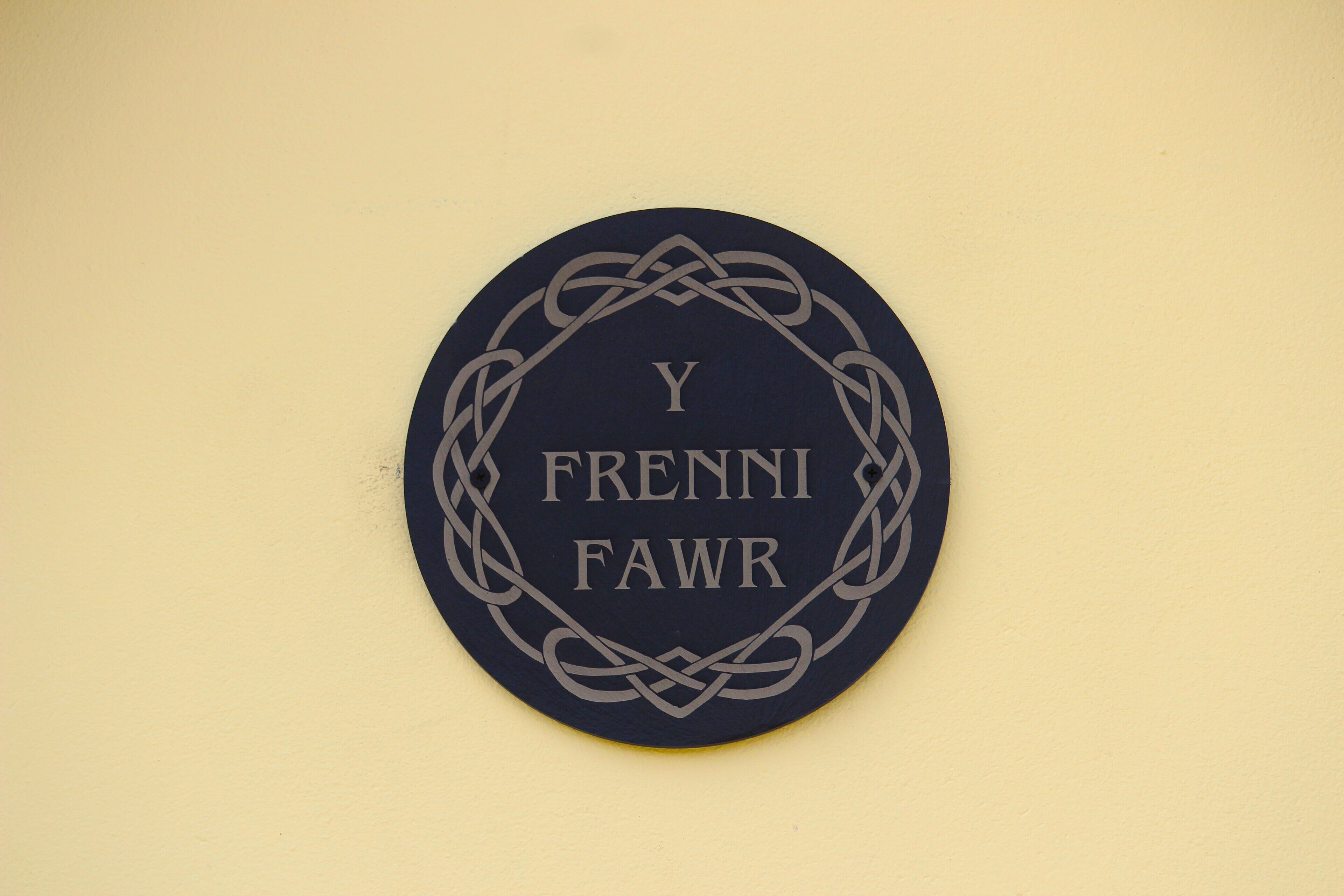 A circular sign with the text "Y Frenn Fawr" surrounded by a decorative border.