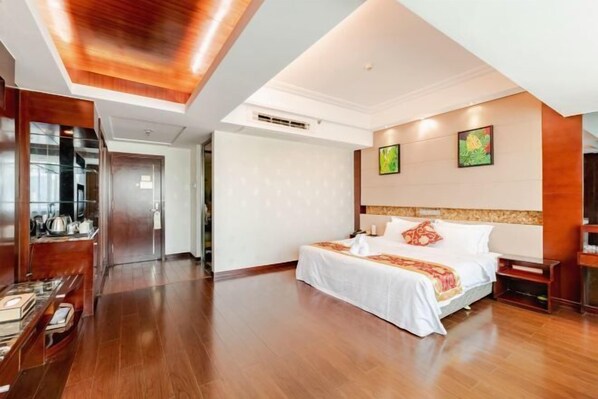A hotel room with a large bed, wooden flooring, a modern ceiling design, and artwork on the walls. - Hainan Hongyun Hotel (Haikou Qilou Old Street) (Haikou)