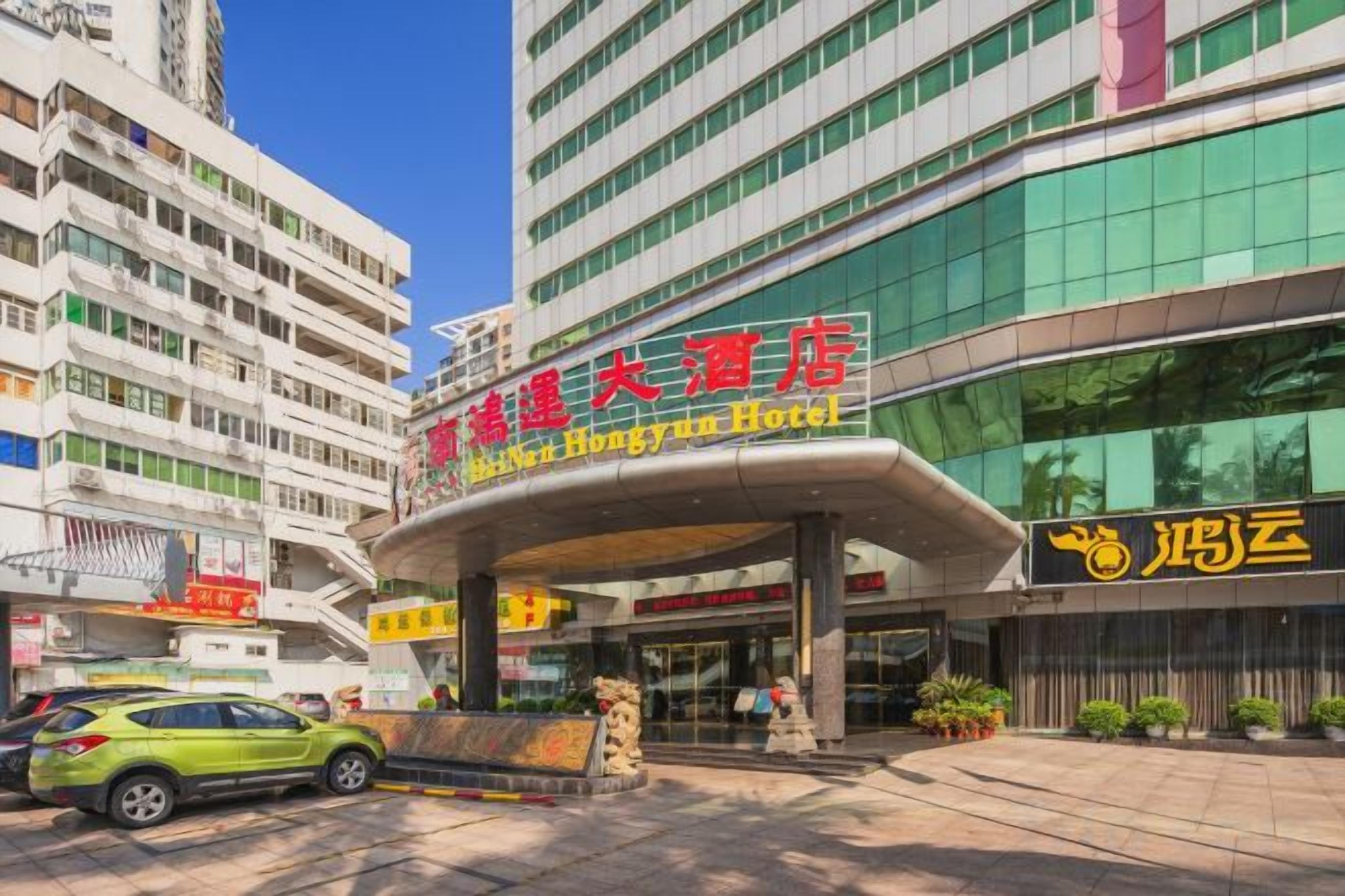 A hotel entrance with a modern design, featuring a curved overhang and a prominent sign.