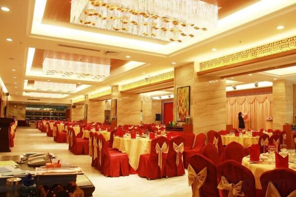A banquet hall with rows of tables and chairs, a stage, and a large chandelier. - Hainan Hongyun Hotel (Haikou Qilou Old Street) (Haikou)