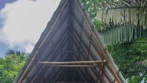 A thatched-roof structure with a wooden framework, surrounded by lush greenery. - Casa Primos - Luxury Home, Casa Primos - Luxury Home - 2 Min Walk to the Beach (Nosara)