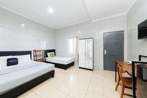 Een hotelkamer met een bed, een bureau, een kledingkast en een televisie.