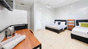 Una habitación de hotel con una mesa de madera, una cama, un televisor y una ventana.