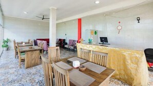 Un vestíbulo de hotel con mobiliario de madera, una recepción y un suelo de baldosas.