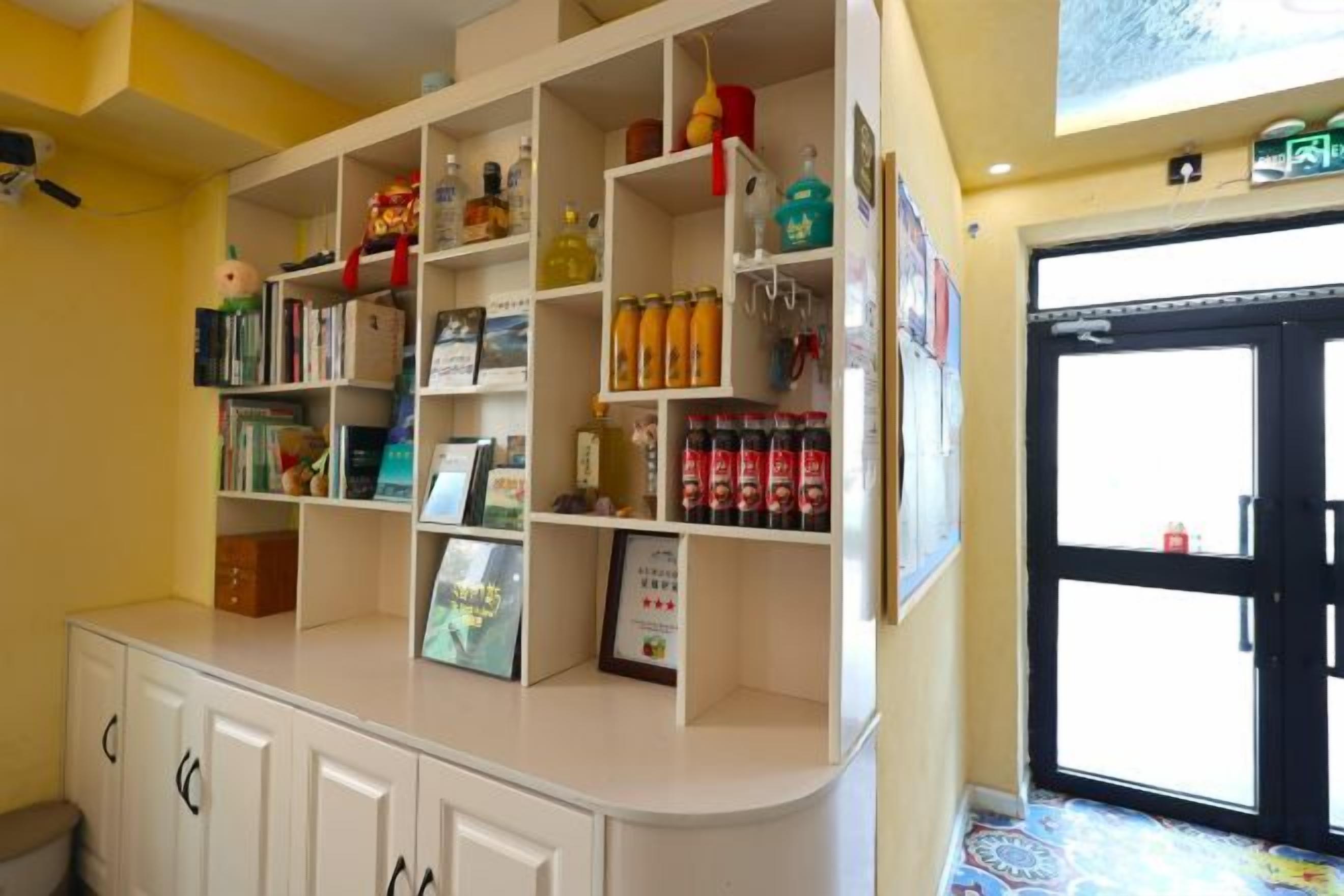 A reception area with a counter, shelves with various items, and a door to the right.