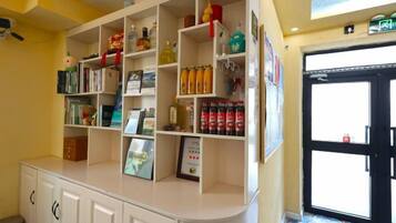 A reception area with a counter, shelves with various items, and a door to the right.