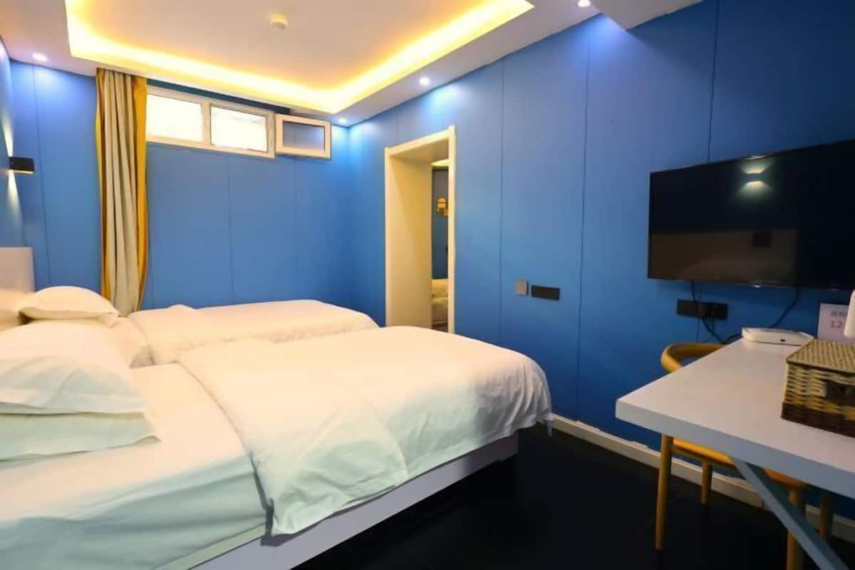 A hotel room with a large bed, a TV, and a table.