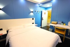 A hotel room with a bed, a desk, a chair, a wardrobe, and a door leading to another room. - Wuwangwo Hotel (Burqin)