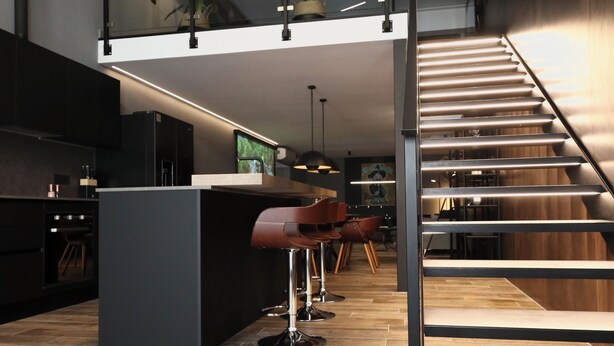 A modern kitchen with a central island, a staircase, and a dining area with chairs. - 180M2-Luxurious-Renovated Holiday LOFT, best rental in Olbia (Olbia)