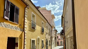 Eine enge Kopfsteinpflasterstraße, gesäumt von historischen Gebäuden mit Balkonen und Bogenfenstern.