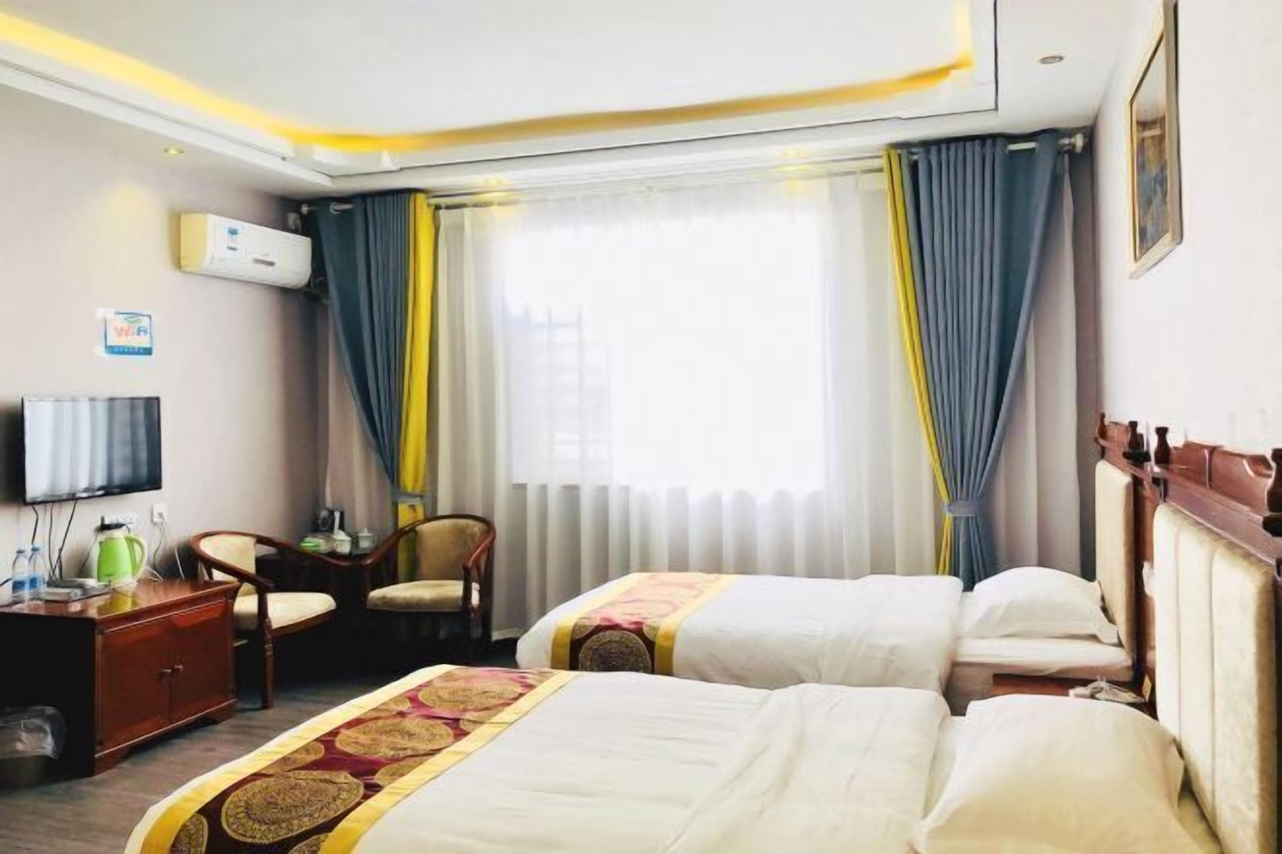 Una habitación de hotel con dos camas, un televisor, un escritorio y una silla.