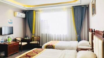 A hotel room with two beds, a TV, a desk, and a chair.